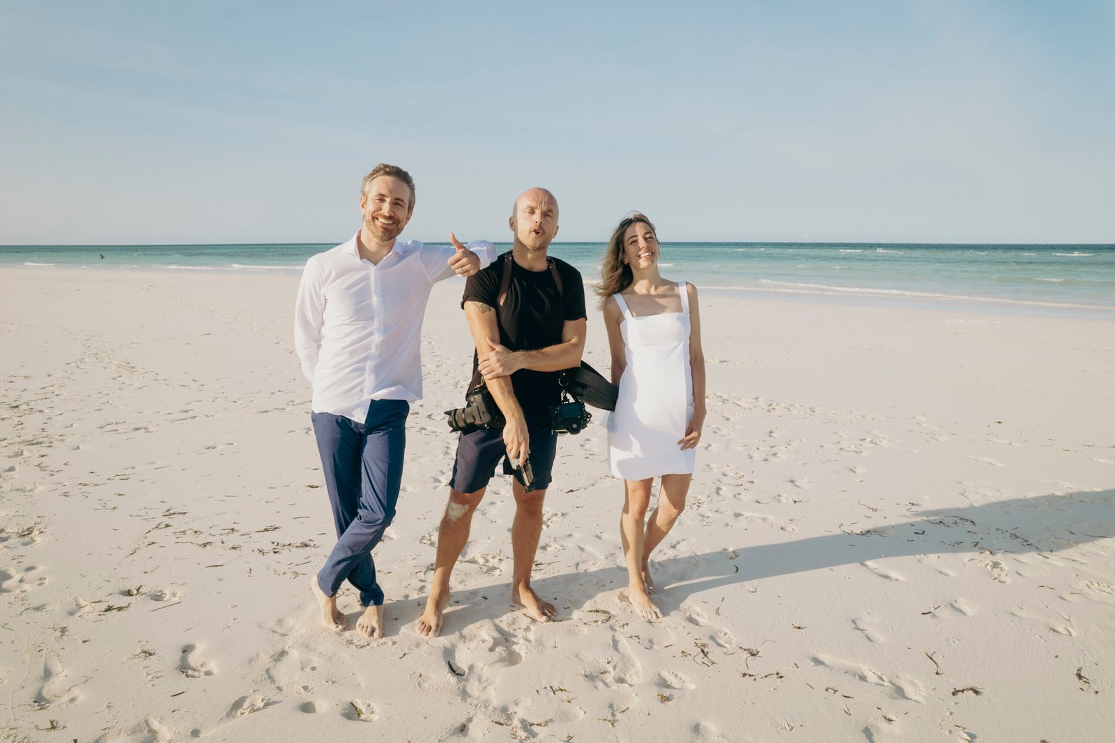 Photographer Michal Dzikowski with a destination wedding couple on a beach in Zanzibar after a wedding photoshoot