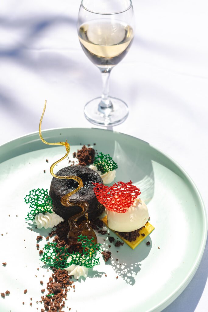 Elegant plated dessert and wine photographed for Gran Melia Arusha luxury hotel dining experience.