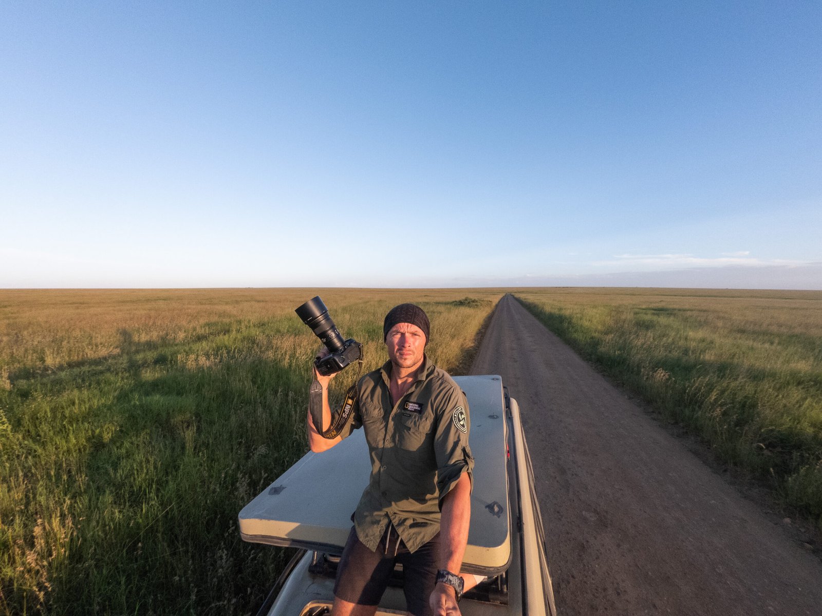 Photographer Michal Dzikowski photographing wildlife in the Serengeti plains during a National Geographic style expedition in Tanzania