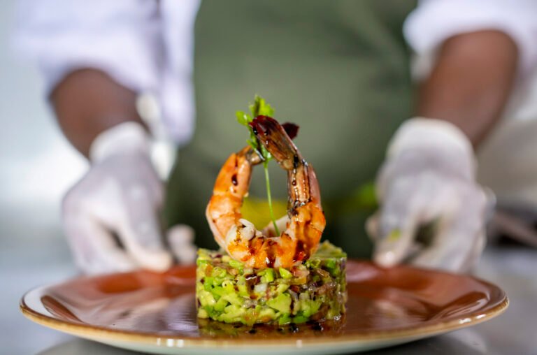 Chef presenting a gourmet prawn dish photographed for Gran Melia Arusha restaurant and hospitality branding.